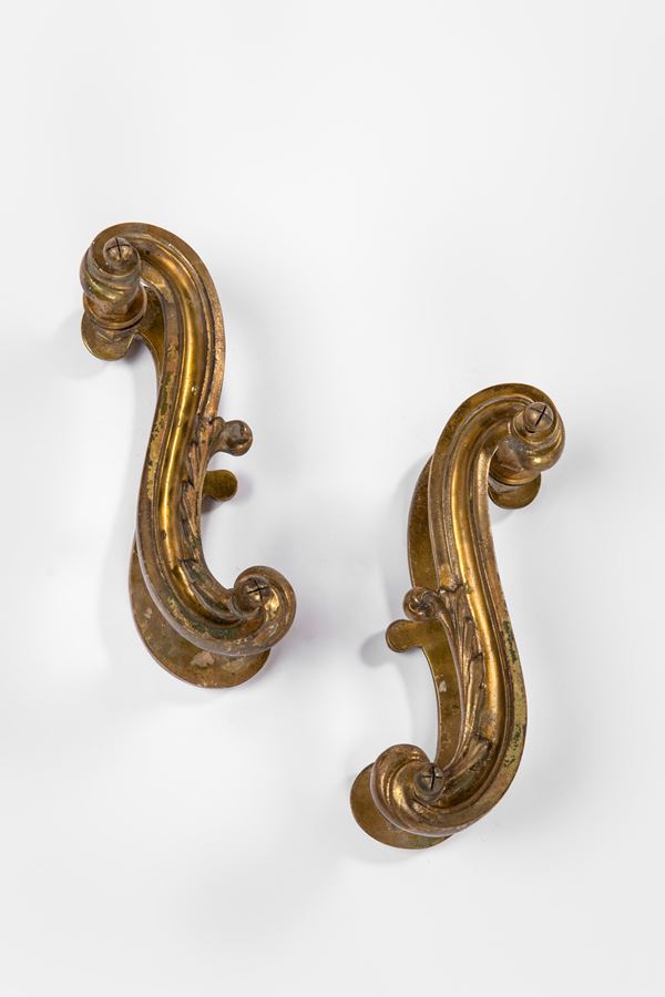 Due coppie di maniglie a forma di volute