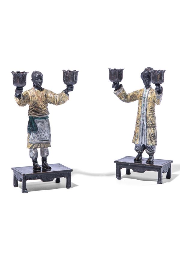 Coppia di candelieri a due luci sorrette da personaggi orientali