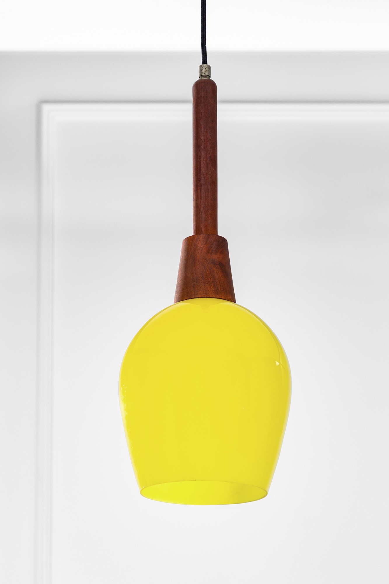 Tre lampade a sospensione, vetro colorato e metallo verniciato, legno massello, circa 1960