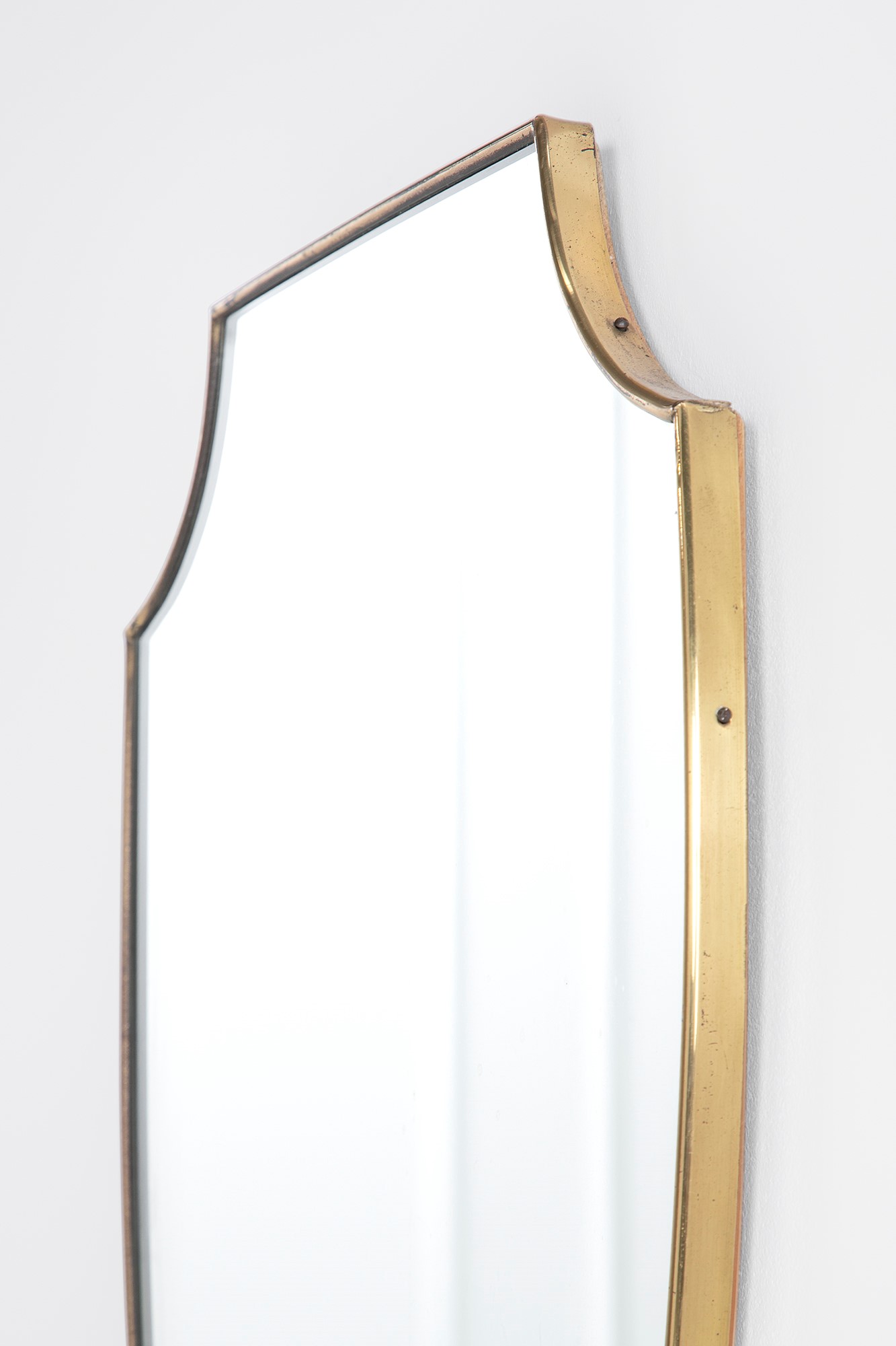 Specchio da parete a scudo, cornice in ottone lucido e vetro specchiato (ca. 1950)